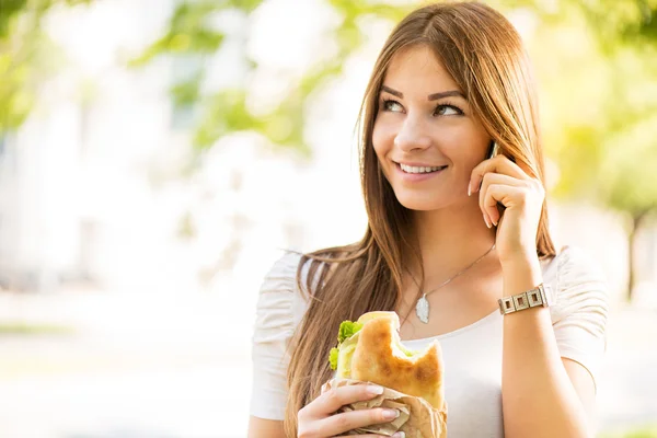 Jonge vrouw met behulp van een mobiele telefoon outoors — Stockfoto