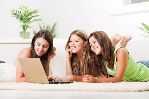 Drie vrolijke vrienden met laptop — Stockfoto