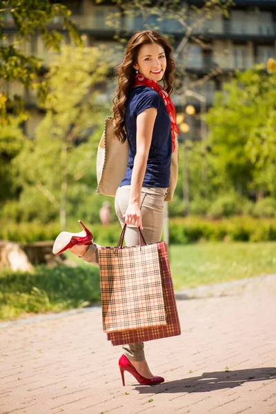 Lycklig flicka med shoppingväskor — Stockfoto