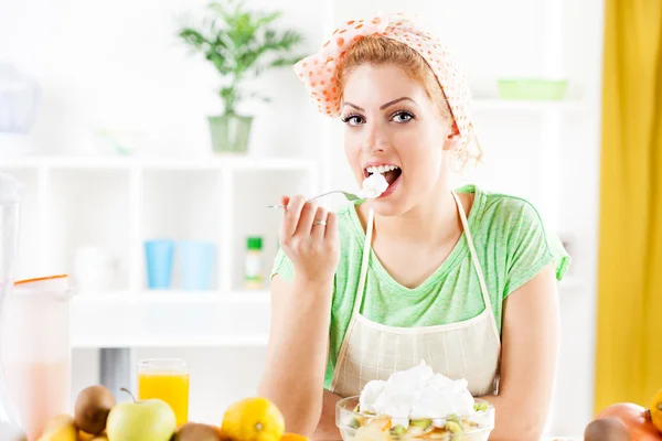 Une jeune femme mange une salade de fruits — Photo