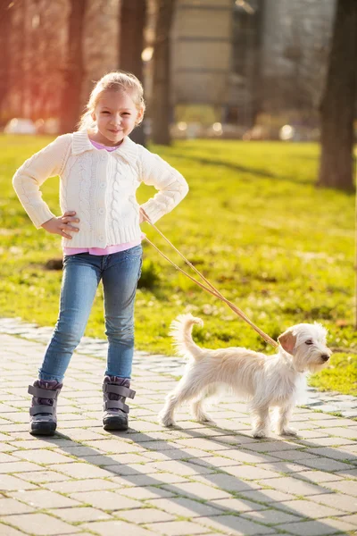 Kleines Mädchen geht mit Welpe im Park spazieren — Stockfoto