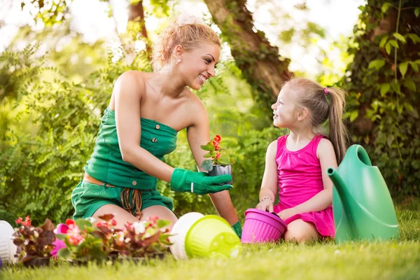 Beautiful mother and daughter planting flowers