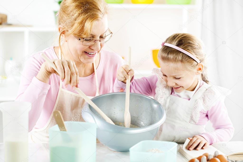 Grandmother and granddaughter in a kitchen.
