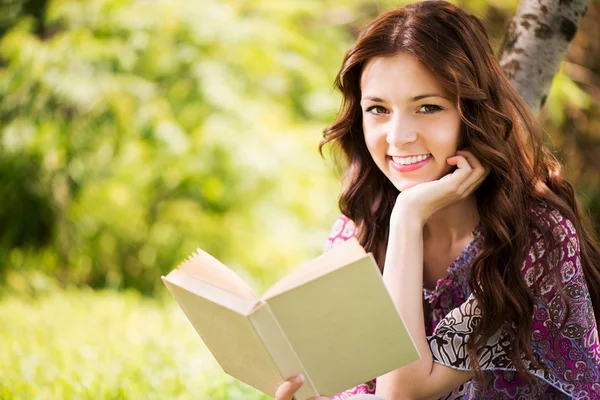 Portrait de fille avec un livre dans le parc — Photo