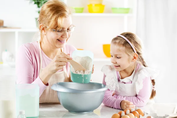 Grootmoeder en kleindochter maken deeg — Stockfoto