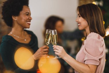 Çok yönlü bayan arkadaşlar yeni yılı ya da Noel 'i birlikte kutlarken şampanyayla kadeh kaldırıyorlar..