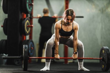 Güzel, formda kadın spor salonunda ağırlık kaldırma egzersizi yapıyor..