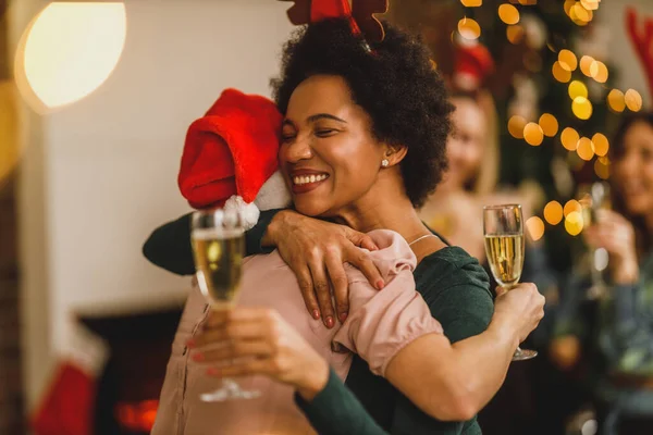 クリスマスや新年を祝うために家に集まった多民族の女性の友人 シャンパンで乾杯 — ストック写真