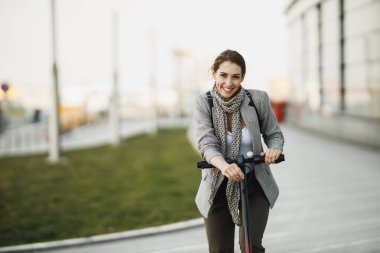 Elektrikli scooter 'ı olan genç bir iş kadını şehirde çalışacak..