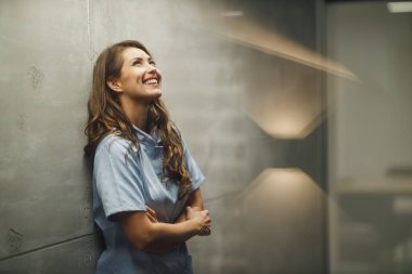 Covid-19 salgını sırasında boş hastane koridorunda kollarını kavuşturmuş çekici genç bir hemşirenin vurulması..