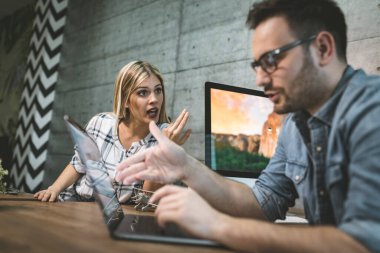 Genç başarılı mühendisler ofiste yeni bir proje üzerinde çalışırken konuşuyor..