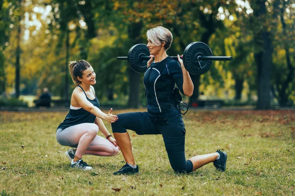 Vältränad Mogen Kvinna Gör Lungövningar Med Personlig Tränare Parken Klädd — Stockfoto