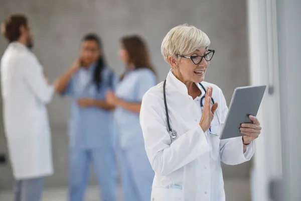 Foto Una Dottoressa Anziana Che Videochiamate Tablet Digitale Corridoio Ospedale — Foto Stock