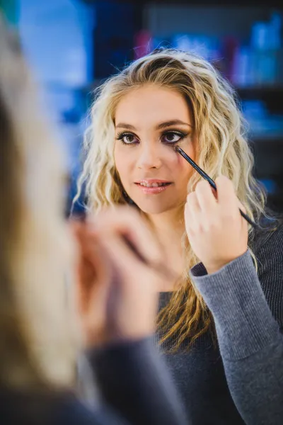 Portret Pięknej Młodej Kobiety Makijaż Patrząc Lustro Stosując Eyeliner Pędzlem — Zdjęcie stockowe