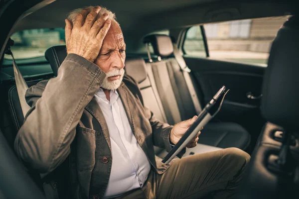 Snímek Ustaraného Seniora Pomocí Digitálního Tabletu Zatímco Sedí Zadním Sedadle — Stock fotografie