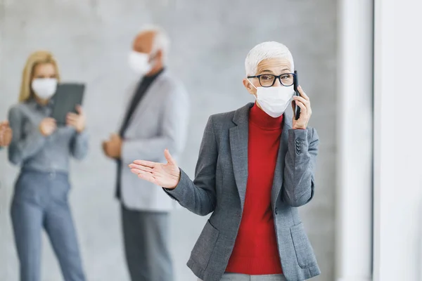 Porträtt Självsäker Senior Affärskvinna Med Skyddande Mask Med Hjälp Smartphone — Stockfoto