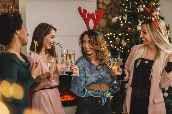 一緒にクリスマスや新年のホームパーティーでシャンパンで乾杯しながら 楽しい多民族の女の子 — ストック写真