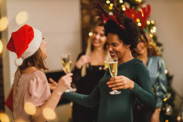 クリスマスや新年を祝うために家に集まった多民族の女性の友人 シャンパンで乾杯 — ストック写真