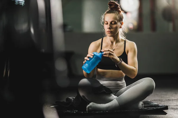 Zastřelen Svalnaté Mladé Ženy Sportovním Oblečení Drží Láhev Vody Odpočívá — Stock fotografie