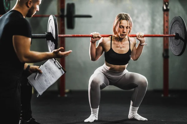 Spor Salonunda Kişisel Antrenörle Çalışan Kaslı Genç Bir Kadın Halterle — Stok fotoğraf