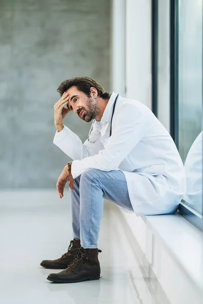 Tired Doctor Having Quick Break Pensive Sitting Empty Hospital Hallway — Stock Photo, Image