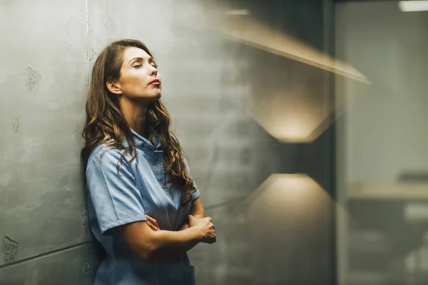 Müde Junge Krankenschwester Mit Verschränkten Armen Steht Leeren Krankenhausflur Und — Stockfoto