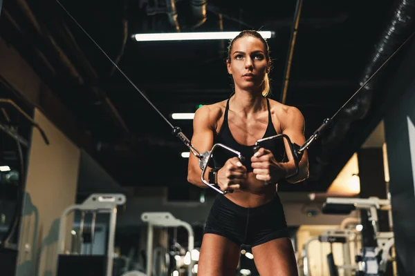 Una Giovane Donna Muscolosa Sta Facendo Allenamento Sulla Macchina Palestra — Foto Stock