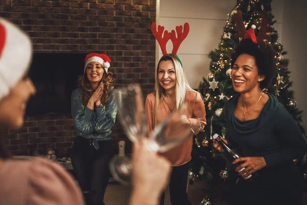 一緒に家で新年やクリスマスを祝いながら 楽しい時間を過ごし シャンパンで乾杯する陽気な多民族女性の友人 — ストック写真