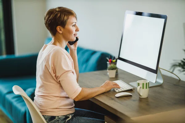 Freelancer Middle Age Woman Talking Cell Phone While Working Computer — Stock Photo, Image