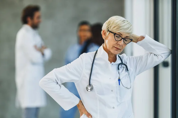 Médico Senior Cansado Mirando Preocupado Mientras Está Pie Junto Ventana —  Fotos de Stock
