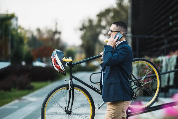 中年のビジネスマンが自転車で仕事に行き 階段の上で彼の肩に自転車を運ぶ — ストック写真