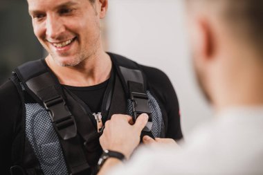 Kişisel antrenörün yakınlaşması spor salonunda çalışan orta yaşlı bir adama yardım etmektir..