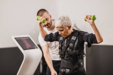 Son sınıf öğrencisi kadın spor salonunda özel antrenörle çalışıyor..