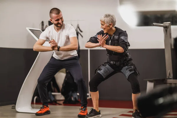 Smiling Senior Woman Doing Ems Working Out Personal Trainer Gym — стоковое фото