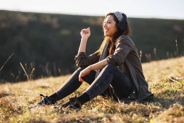 Linda Joven Sonriente Escuchando Música Sus Auriculares Mientras Está Sentada —  Fotos de Stock