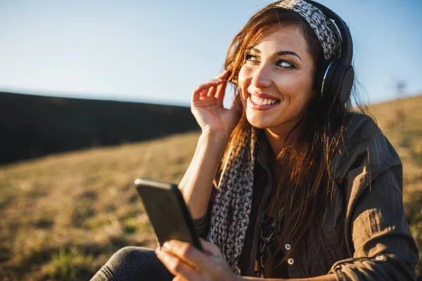 Carino Sorridente Giovane Donna Ascoltando Musica Dal Suo Smartphone Mentre — Foto Stock