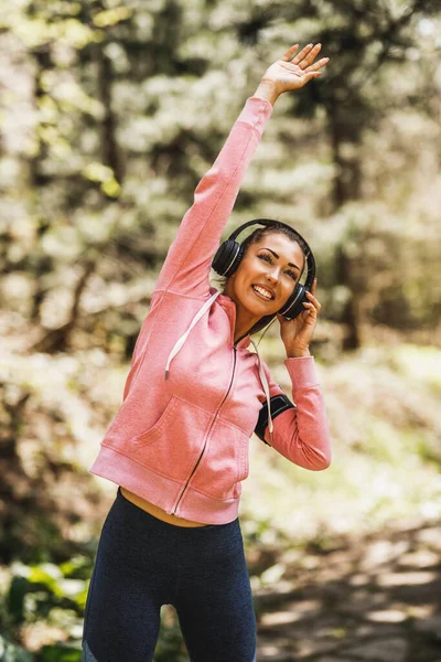 Młody Piękny Uśmiechnięty Kobieta Biegacz Słuchając Muzyki Podczas Rozciągania Jogging — Zdjęcie stockowe