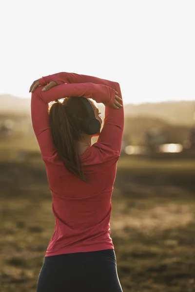 Ung Vacker Leende Kvinnlig Löpare Lyssnar Musik Medan Stretching Efter — Stockfoto