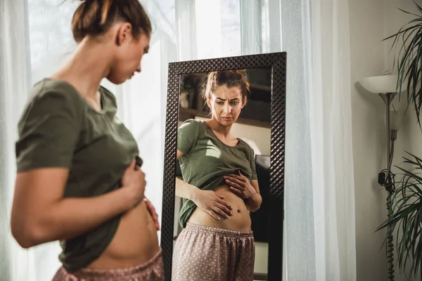 Ongelukkige Vrouw Die Voor Een Spiegel Staat Haar Maag Vasthoudt — Stockfoto