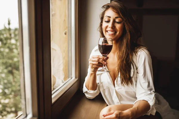 Söt Leende Pensiv Kvinna Dricker Rött Vin Medan Står Nära — Stockfoto