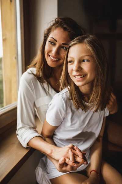 Cute Smiling Girl Her Young Mother Looking Window While Enjoying — Φωτογραφία Αρχείου