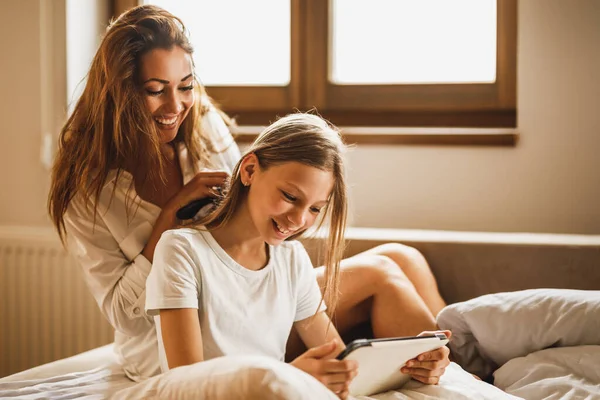 Young Smiling Happy Mother Combing Her Little Daughter Hair Bed — Stockfoto