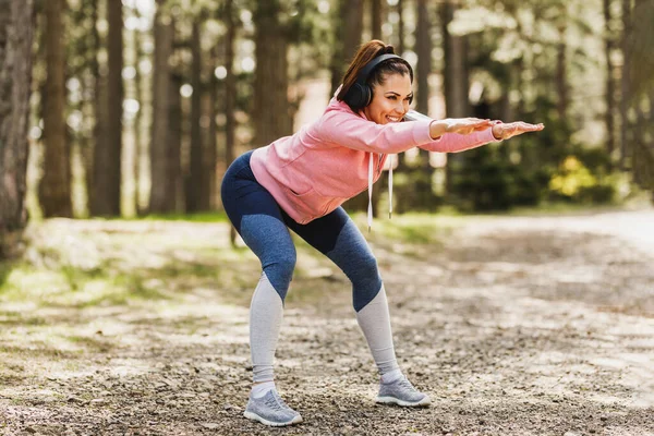 Ung Vacker Leende Kvinnlig Löpare Lyssnar Musik Medan Stretching Efter — Stockfoto