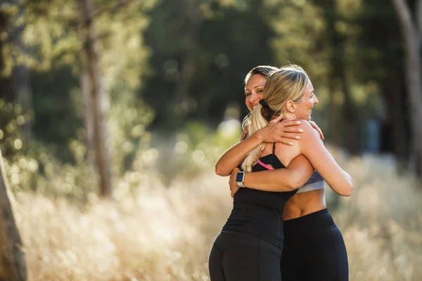 Two Fit Middle Age Women Greeting Hug Training Pine Forest — Φωτογραφία Αρχείου