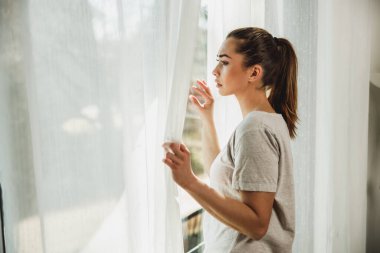 Depresyondaki yalnız genç kız pencereden dışarı bakıyor. Kötü karamsar düşünceler içinde kaybolmuş..