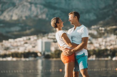 A loving cheerful casual couple enjoying a summer vacation at the Mediterranean.