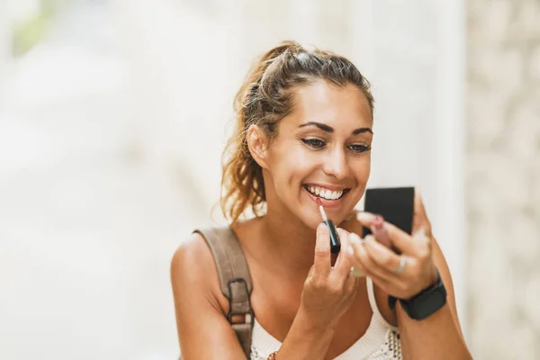 Portrait Young Smiling Woman Using Hand Mirror Applying Lipstick While — Stockfoto