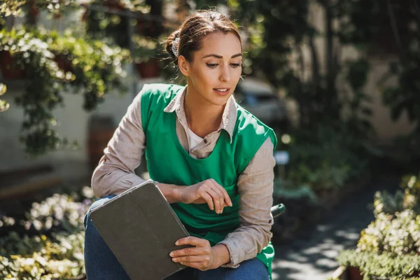 Young Skilled Woman Holding Digital Tablet Checking Potted Plants Greenhouse — Stockfoto