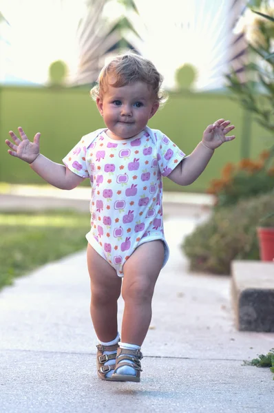 De eerste onafhankelijke stappen van een meisje van de baby — Stockfoto