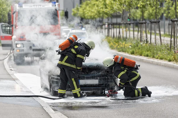 Tűzoltók hozataláért ki egy égő autó — Stock Fotó
